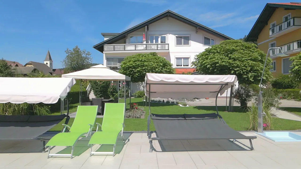 Langsame Fahrt am Pool entlang, vorbei an Liegen und Doppelliegen, im Hintergrund das Haus