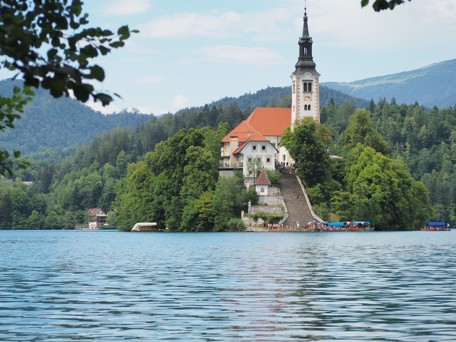 Die Insel im Bleder See mit der Wallfahrtskirche, umgeben von grünem Wald
