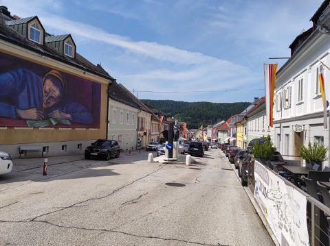 Hauptplatz von Bleiburg mit bunten Bürgerhäusern und großem Wandbild