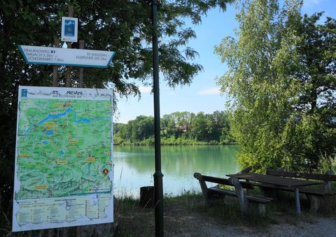 Rastplatz am Drauradweg R1 bei St. Kanzian mit Wegweiser, Radkarte und Blick auf die Drau