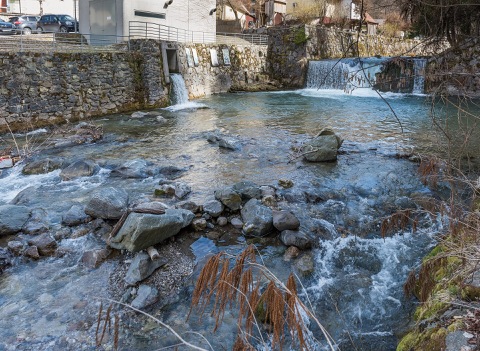 Die Vellach fließt über Steine und kleine Wehre durch Bad Eisenkappel