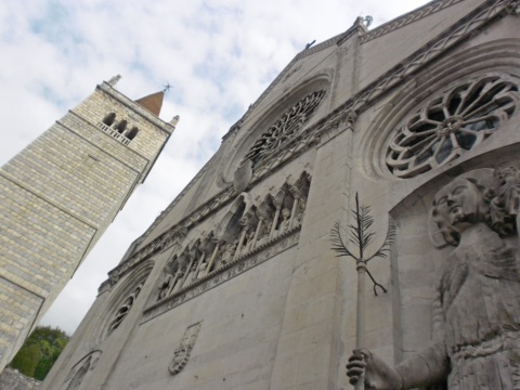 Fassade des Doms von Gemona mit Fensterrosen, Christophorus-Statue und Glockenturm
