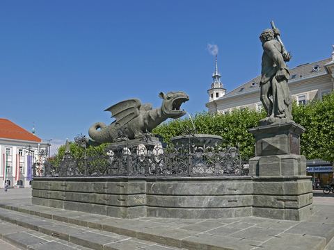 Der Lindwurmbrunnen am Neuen Platz in Klagenfurt unter blauem Himmel