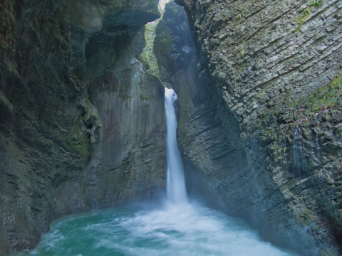 Der Kozjak-Wasserfall stürzt in einer engen Felsgrotte in ein türkisgrünes Becken