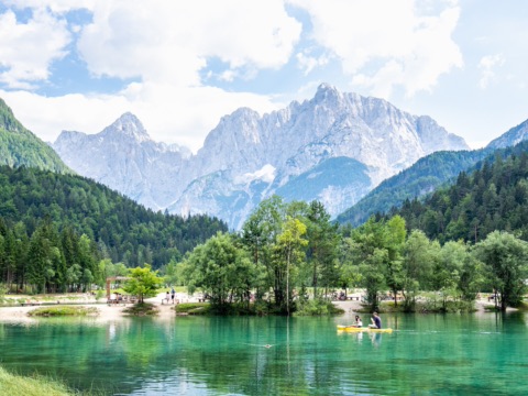 Türkisgrüner Jasna-See mit Kajak vor den Felsgipfeln der Julischen Alpen