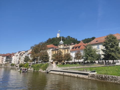 Burgberg von Ljubljana mit Burgturm über den Häusern am Ufer der Ljubljanica