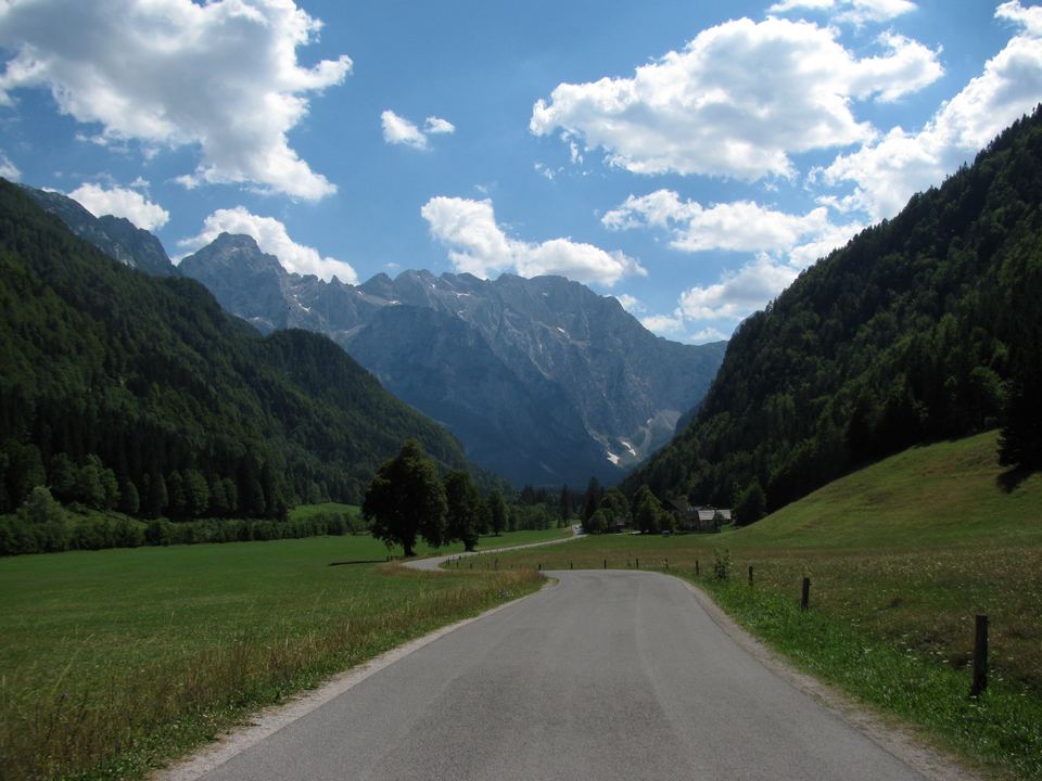 Straße durch das grüne Logartal, umrahmt von den Gipfeln der Steiner Alpen