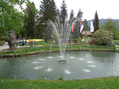 Springbrunnen zwischen Blumenbeeten im Blumenpark Mozirski gaj