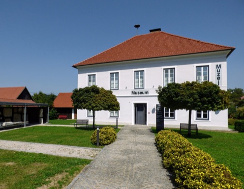 Weißes Museumsgebäude mit rotem Walmdach und der Aufschrift „Museum“ in Globasnitz