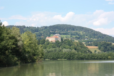 Schloss Neudenstein auf einem bewaldeten Hügel über dem Völkermarkter Stausee
