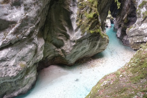 Türkisfarbenes Wasser zwischen glatt geschliffenen Felswänden in der Tolminer Klamm