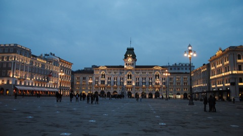Die Piazza Unità d'Italia in Triest am Abend mit dem beleuchteten Rathaus