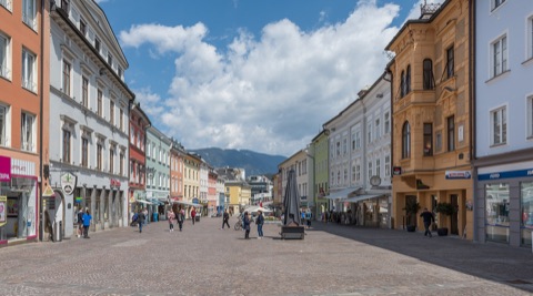 Hauptplatz in der Villacher Altstadt mit bunten Bürgerhäusern und Bergen im Hintergrund