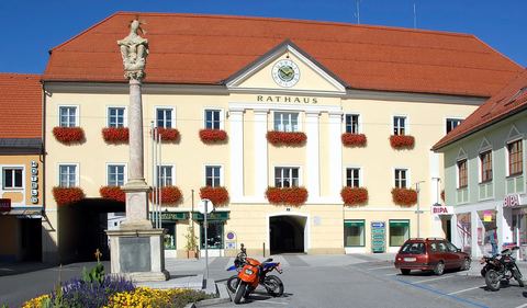 Das Rathaus am Hauptplatz von Völkermarkt mit Blumenschmuck und Dreifaltigkeitssäule