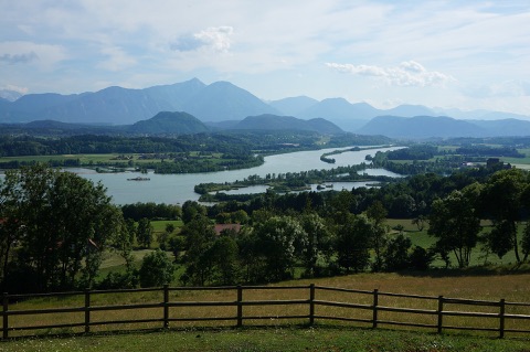 Blick über die bewaldeten Inseln und Buchten des Vogelschutzgebiets am Völkermarkter Stausee, im Hintergrund die Karawanken