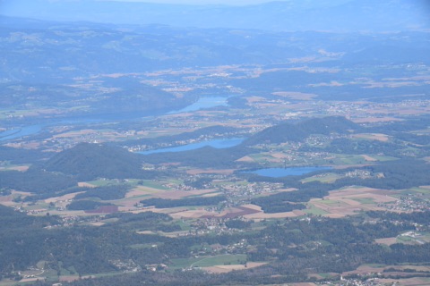 Blick vom Obir nach Nordosten über Südkärnten mit der Drau, dem Klopeiner See und dem Turnersee zwischen Wäldern, Feldern und Dörfern