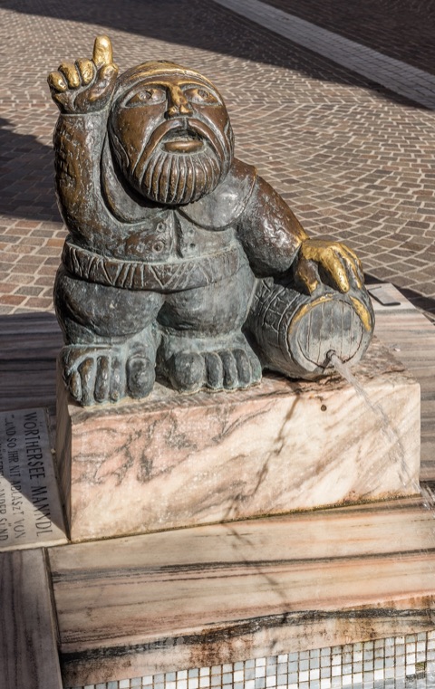 Bronzefigur des Wörtherseemandls mit Fass am Brunnen in der Klagenfurter Innenstadt