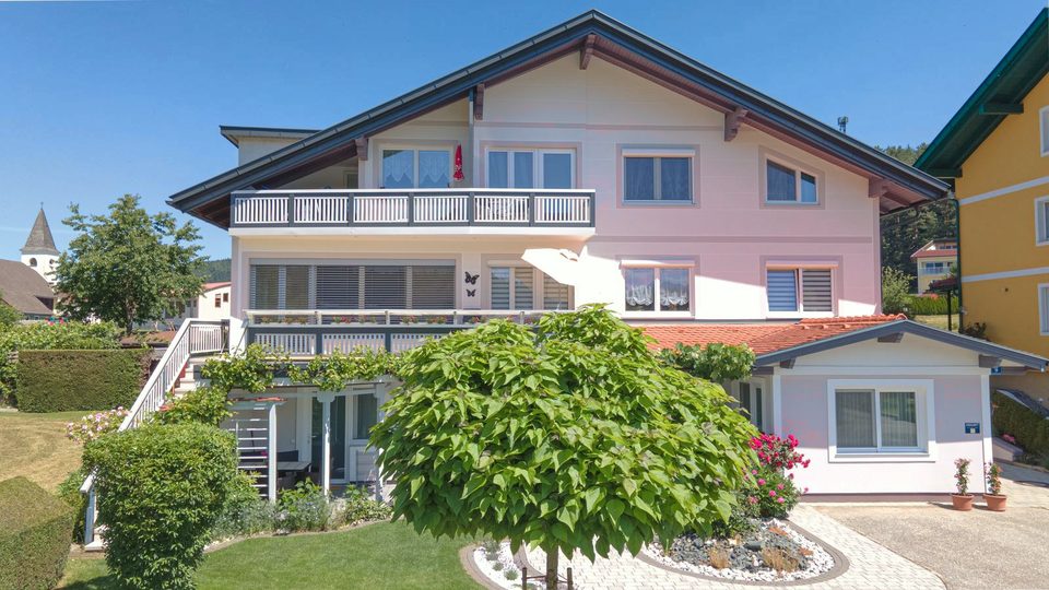 Vorderansicht des Hauses mit Kugelbaum und Blumenbeet