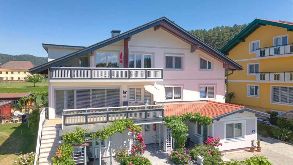 Seitenansicht des Hauses mit Balkonen und Rosen an der Pergola