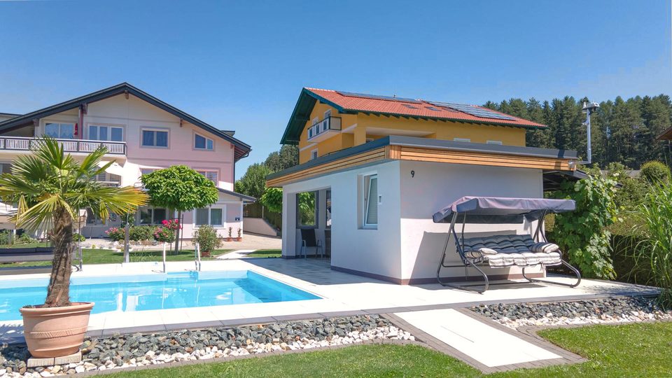 Badehütte mit Hollywoodschaukel und Palme neben dem Pool