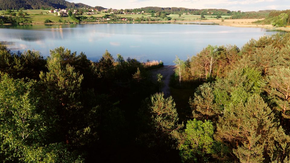 Badesee hinter Wäldern aus der Vogelperspektive, Turnersee-Gebiet
