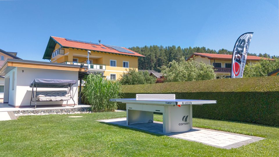 Tischtennistisch aus Beton auf der Wiese neben der Badehütte