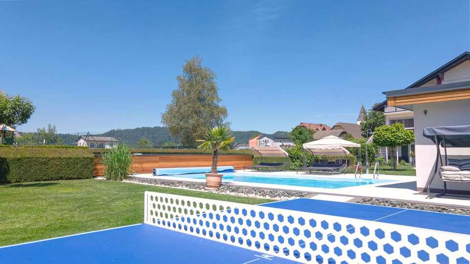 Tischtennisplatte im Vordergrund, dahinter der Pool