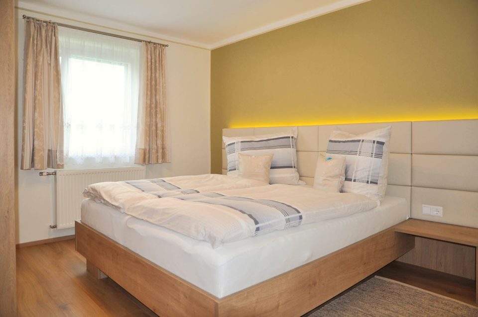 Doppelzimmer mit Lichtleiste und olivgrüner Akzentwand