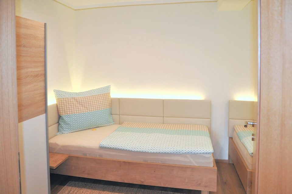 Dreibettzimmer mit Lichtleiste und gepolstertem Kopfteil