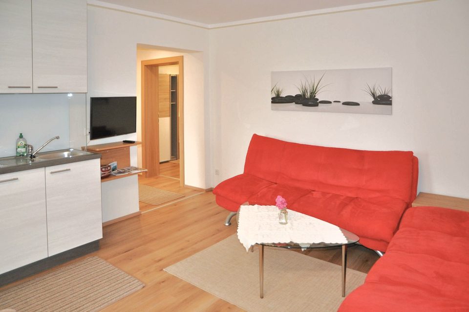 Wohnbereich mit Ecksofa, Couchtisch und Küchenzeile
