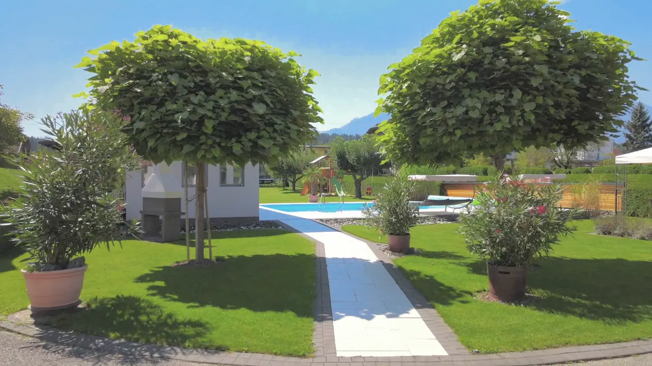 Spaziergang auf dem Gartenweg unter Kugelbäumen zum Pool